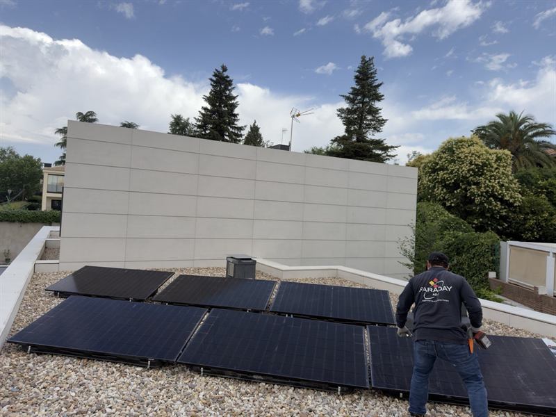 Operario de Faraday ADJ instalando paneles fotovoltaicos sobre cubierta plana